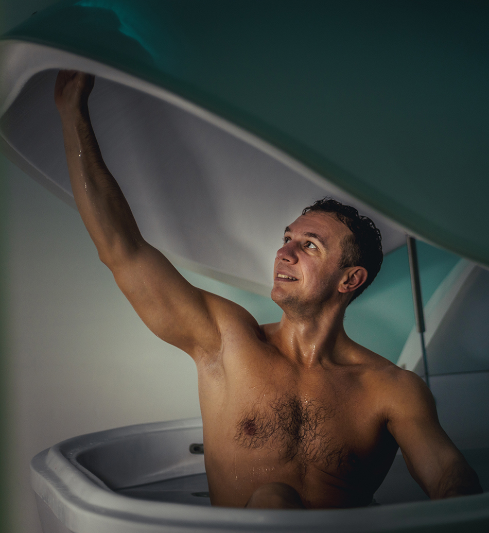 Floatation Tank Therapy Relaxed man is floating in a sensory deprivation tank. He is very relaxed. Wellness and Spa concept.